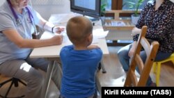 Мальчик с мамой на приеме у доктора в детском хосписе "Радуга". Фото иллюстративное
